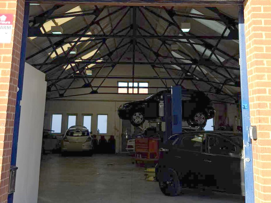 Inside the A-Tech Service Centre workshop with a car on the lift